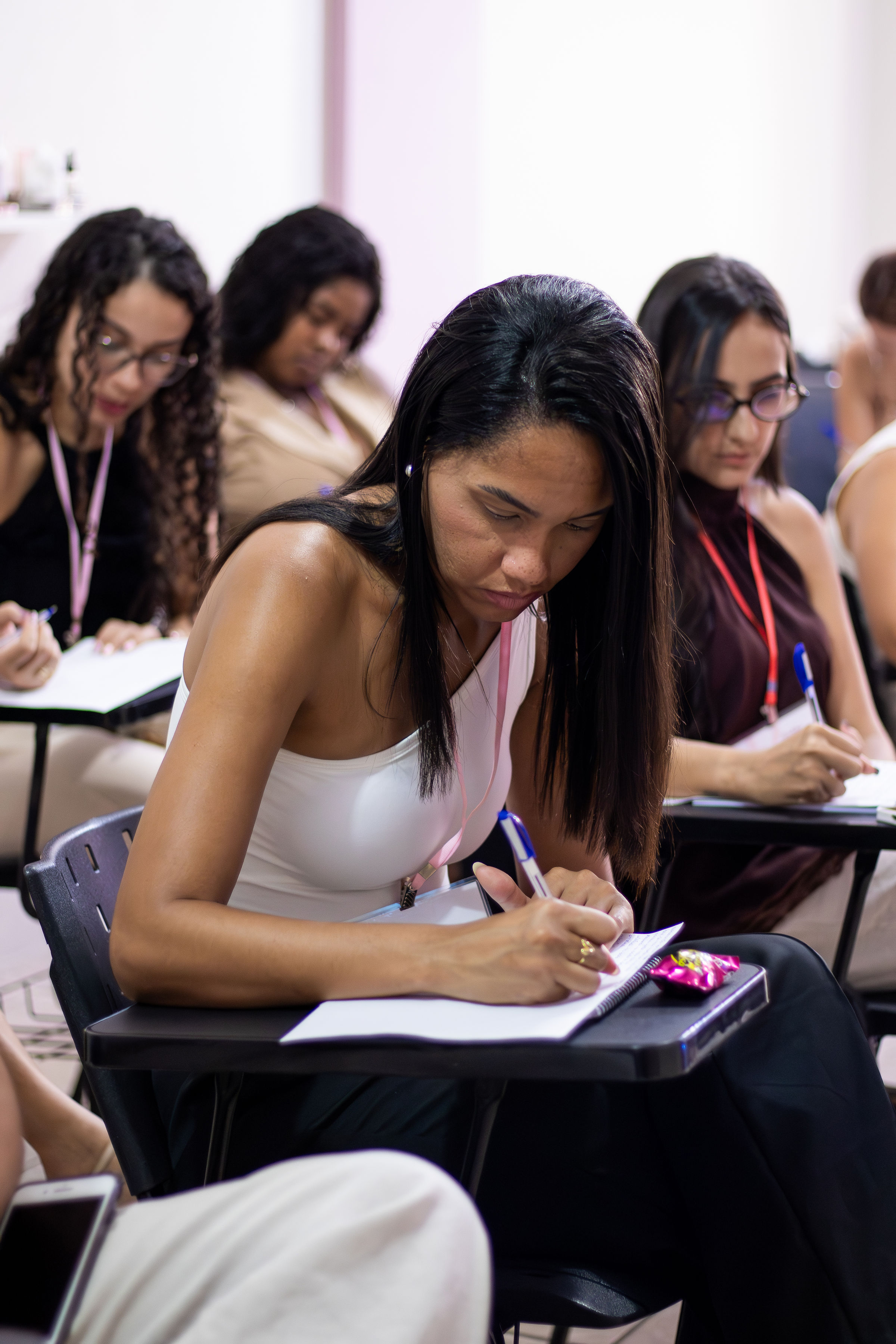 Profissional da beleza acompanhando o conteúdo e escrevendo em seu caderno